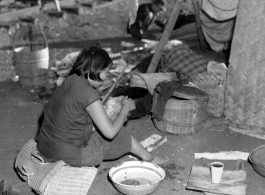 In the midst of calamity, a refugee mother tenderly washes her baby next to the train at the Liuzhou railway station in the fall of 1944.