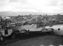 A bone yard of wrecked American military aircraft during WWII at Luliang, Yunnan province, China, looking east.  In this image are easily recognized C-46 and B-24 air frames.