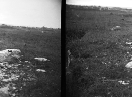 A stone worker hunched over in his rain slicker in the rain. Luliang, China, during WWII.