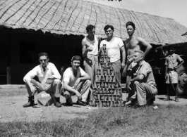 GIs with beer can pyramid during WWII.  Americans in the CBI. Probably India.