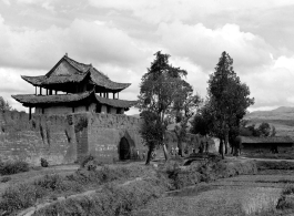 A city wall with gate (probably at Chengkung/Chenggong) and local people in Yunnan province, China.