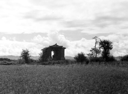 Men pass through a bridge covered in a structure of adobe bricks and wood, in the countryside in Yunnan province, China.