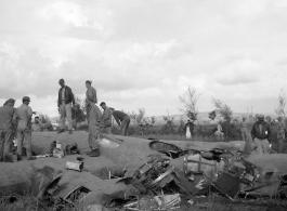 GIs inspect crashed B-24 in a grainfield in China during WWII, between 1943-1945. 