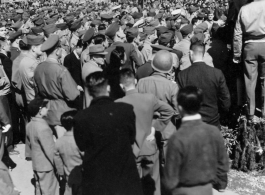 Burma Road dedication parade and ceremony in Kunming, China, on or around February 4, 1945, during WWII. Review of first convoy (or one of the first convoys) to reach China. Ranks of soldiers and civilians. Note movie camera filming on top.