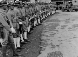 Burma Road dedication parade and ceremony in Kunming, China, on or around February 4, 1945, during WWII. Review of first convoy (or one of the first convoys) to reach China. Chinese soldiers marching in fancy parade dress during, waiting for their turn in the parade.