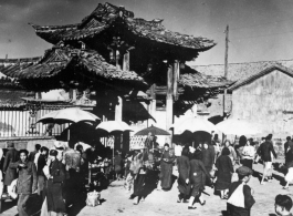 Local people in Yunnan province, China, during WWII: People come and go through gate.