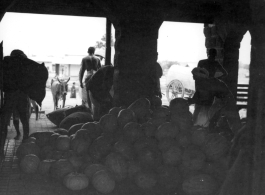 Large pile of melons or pumpkins.  Scenes in India witnessed by American GIs during WWII. For many Americans of that era, with their limited experience traveling, the everyday sights and sounds overseas were new, intriguing, and photo worthy.