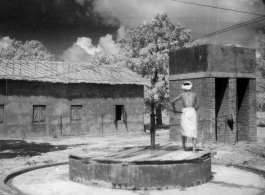 Man pumps water from a well up to a raised cistern.  Scenes in India witnessed by American GIs during WWII. For many Americans of that era, with their limited experience traveling, the everyday sights and sounds overseas were new, intriguing, and photo worthy.