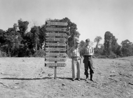 GIs pose before road sign on Burma Road.  797th Engineer Forestry Company.  During WWII.