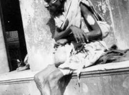 Man begs on road in town in Burma or India.  Near the 797th Engineer Forestry Company.  During WWII.