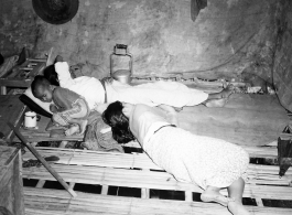 People sleeping inside home in Burma.  In Burma near the 797th Engineer Forestry Company.  During WWII.