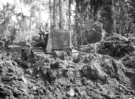 Bulldozer pushing dirt in Burma.  797th Engineer Forestry Company in Burma.  During WWII.