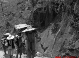 Bearers carry people in sedan chairs up mountain in northern China during WWII.