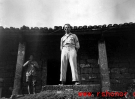 A GI stands in a doorway of a building in China during WWII.