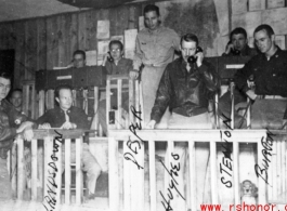 Scene of the workings of the Fighter Control Squadron, 51st Fighter Group, 14th Air Force, as the team works to plot and intercept Japanese planes. Left to right: Lt. Raymond E. Wilson, Capt. Spencer Lansdown, Capt. Dale D. Desper, Col. Louis R. Hughes, Jr., Capt. Thomas E. Stenton, "Buttons" the puppy, and Capt. Glade C. Burton.