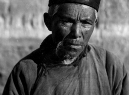 An elderly man poses for the photographer in China during WWII.