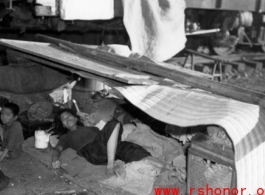 A Chinese refugee resting and hiding from the heat near a train at Liuzhou during the evacuation in Guangxi during the fall of 1944. 