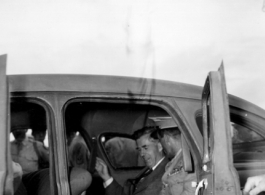 Chennault and an American VIP sit in a car in China during WWII.