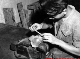 A Chinese worker repairs a piston by hand at an American base in China during WWII.