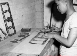 A Chinese work rehabilitates engine gaskets by hand in China during WWII.