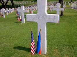 Cross marker at the Manila American Cemetery and Memorial in the Philippines. The site occupies 152 acres on a prominent plateau, visible at a distance from the east, south and west. It contains the largest number of graves of our military dead of World War II, a total of 17,202, most of whom lost their lives in operations in New Guinea and the Philippines. The headstones are aligned in 11 plots forming a generally circular pattern, set among masses of a wide variety of tropical trees and shrubbery.  The ch