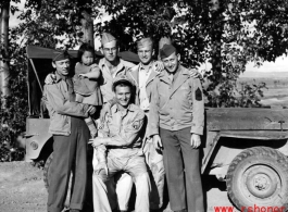 Smiling GIs pose with small child from well-to-do family in China, during WWII.