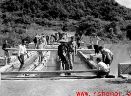 Getting a few last vehicles across a bridge at Liuzhou before the Japanese advance in the fall of 1944. The bridge decking planks have been removed, but there are enough free planks that by moving a few planks, then moving forward a bit on those planks, then moving a few more planks, the jeep can creep across.