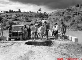 Getting a few last vehicles across a bridge at Liuzhou before the Japanese advance in the fall of 1944. The bridge decking planks have been removed, but there are enough free planks that by moving a few planks, then moving forward a bit on those planks, then moving a few more planks, the jeep can creep across.