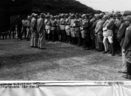 Colonel Norman McNeill, Inf., American commandant and senior instructor of the Chinese General Staff School introduces a B-24 bomber pilot of Maj. Gen. Claire Chennaults 14th Air Force to Chinese officers attending the school at a 14th Air Force base...