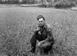 An American soldier in the CBI kneeling in a fallow rice paddy in China during WWII.