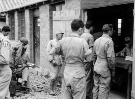 "'Stateside' folding money being handed out on payday by Lt. COl. John H. Williamson, CO of the Fourteenth Air Force Transport Unit to men of his command."