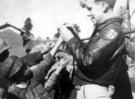 Sgt. Robert H. Zolbe, with kids in China (almost certainly Yunnan Province), handing out candy. Zolbe served in the 308th Bombardment Group, 425th Squadron on a B-24 bomber.