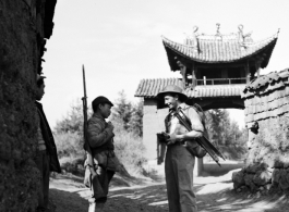 A photographer walking the paths of a village in Yunnan province stops to engage a Chinese soldier.