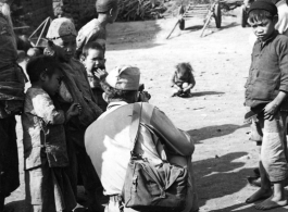 An American photographer interact with local people in a village in Yunnan during WWII.