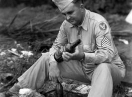 An American in the CBI sorts through booze bottles and coconuts during WWII.