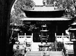 The central courtyard of local Buddhist temple in  China, probably in Yunnan province, with large bronze incense burner. During WWII.