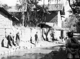 Local people near Yangkai, Yunnan province, China, walk a village pathway. During WWII.