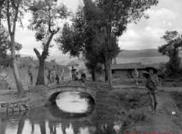 A small bridge near a town wall, with local people  in Yunnan province, China.  From the collection of Eugene T. Wozniak.