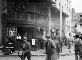 Local people in Kunming, Yunnan province, China: A busy street corner and food shop.