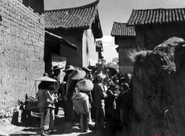 Villagers check out and American cameraman in a village in Yunnan province, China. During WWII.