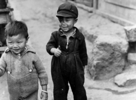 Local kids in China: Boy and girl on the side of the street in SW China during WWII.