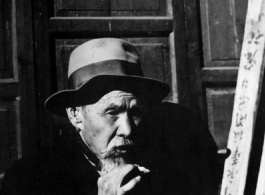 Local people in China: An old man smoking. During WWII.