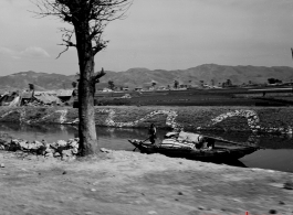 Local people and boat in near Kunming, China, during WWII.