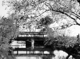 Local scenery in Yunnan province, China, during WWII: A covered pedestrian bridge over a canal.  From the collection of Eugene T. Wozniak.