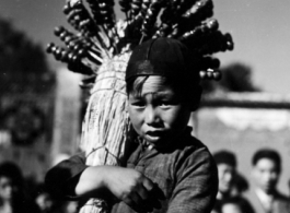 During WWII, a child sells candied fruit on the street, probably in Yunnan.  Local people in China, including a young candied fruit seller selling candied haws fruit on bamboo skewers.