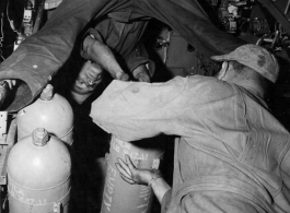 Chinese American Composite Wing (CACW) --"CHINESE AIRMEN GET AMERICAN TRAINING AND EQUIPMENT." The photographer must have laid on his back to get this photo of the Chinese and American crew loading bombs into the rack of a B-25 Mitchell medium bomber.  During WWII in China.  Images courtesy of Tony Strotman.