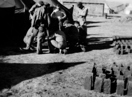 A handful of GIs huddle at a tent city at a base near "Kunming, China" during WWII.