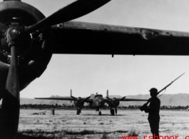 Chinese soldier keeps guard over B-25s in SW China during WWII.