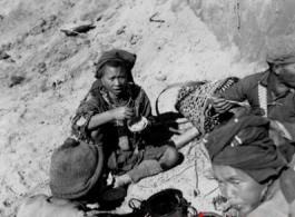 Workers take a break to eat, possibly resting from road building in SW China or Burma. During WWII.