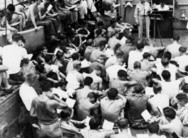 GIs gathered for a Protestant church service on deck of a ship (the Marine Raven) on the return voyage back to the US after the war.  In the CBI during WWII.